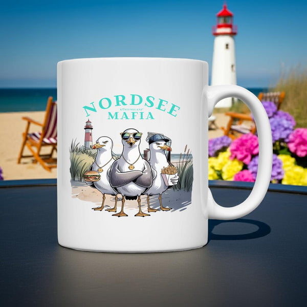 Weiße Keramiktasse mit drei coolen Comic-Möwen (mit Sonnenbrille/Mütze) und dem Text "Nordsee Mafia".